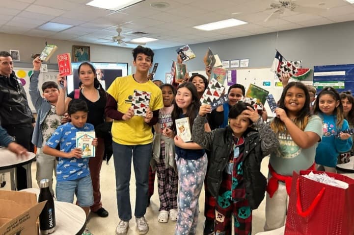 Rohan Satija (yellow shirt) donates books to schools through his nonprofit Let’s Learn Foundation.