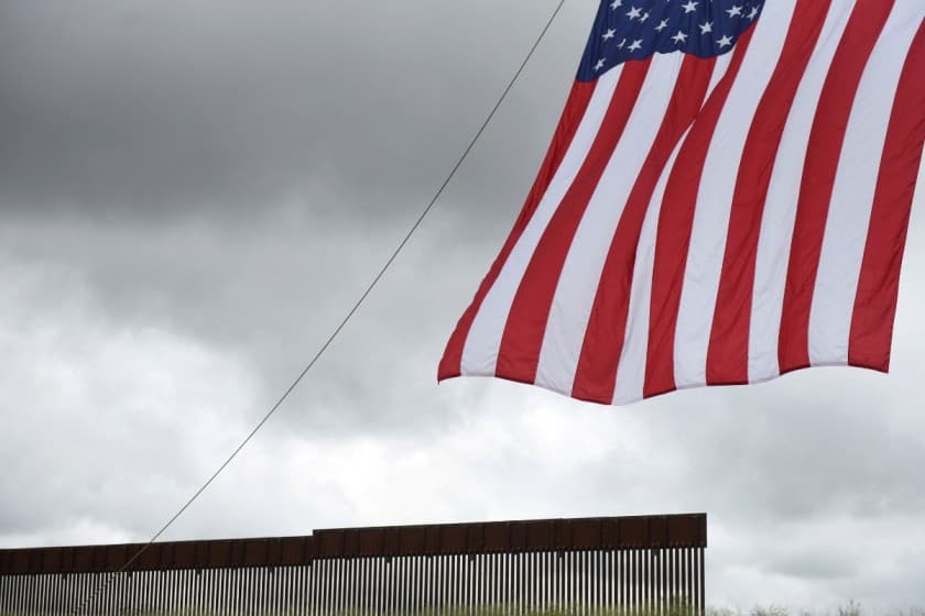 FILE PHOTO: A flag flies in front of a section of the border wall along the U.S.-Mexico border in Pharr, Texas, U.S. June 30, 2021. REUTERS/Callaghan O'Hare/File Photo