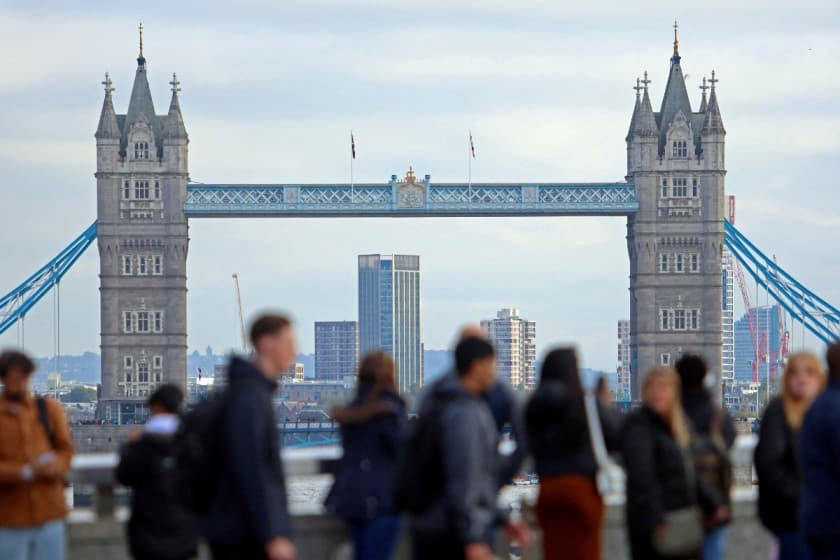 People walk over London Bridge looking at a view of Tower Bridge in the City of London financial district in London, Britain, October 25, 2023. REUTERS/ Susannah Ireland/File Photo
