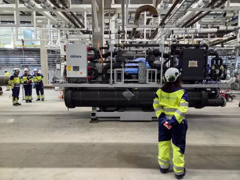 FILE PHOTO: Visitors look at a heat pump that awaits assembling inside utility Fortum’s heat pump room that is under construction next to Microsoft’s new data centre site in Kirkkonummi, Finland March 7, 2025.