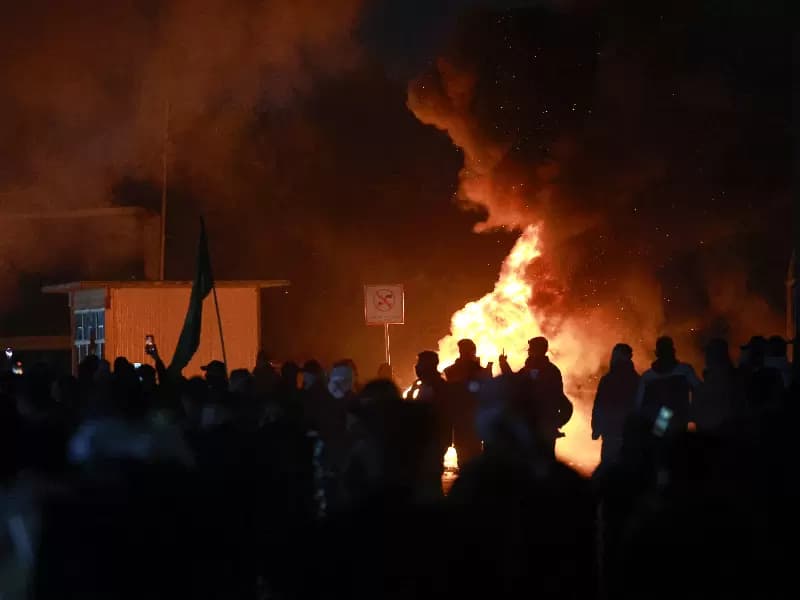 A smoke billows from a fire as supporters of Iraqi Shi'ite armed groups attempt to move toward the U.S. embassy located in Baghdad's Green Zone, while riot police deploy to block their advance, following the Israel and U.S. strikes on Iran and the killing of Iran’s Supreme Leader, in Baghdad, Iraq, March 1, 2026. 