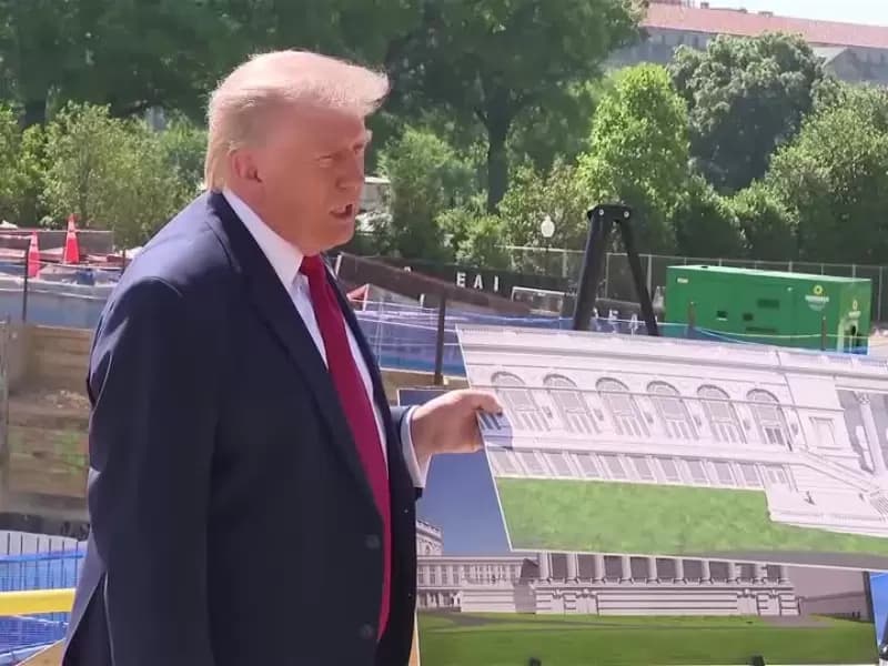 U..S. President Donald Trump shows images of the concept at the site of ongoing construction of the planned White House ballroom in Washington, D.C., U.S., May 19, 2026.