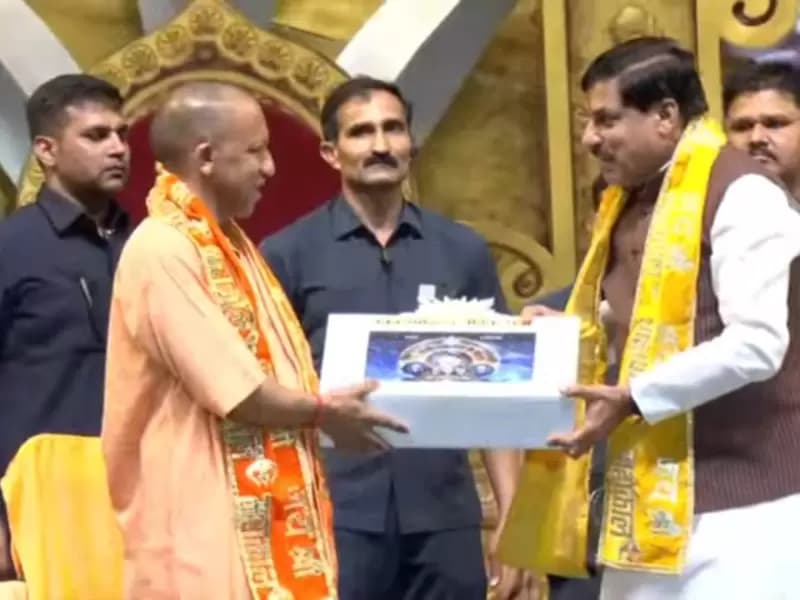 Chief Minister of Madhya Pradesh Mohan Yadav presenting a model of the Vikramaditya Vaidik Ghadi to Uttar Pradesh CM Yogi Adityanath