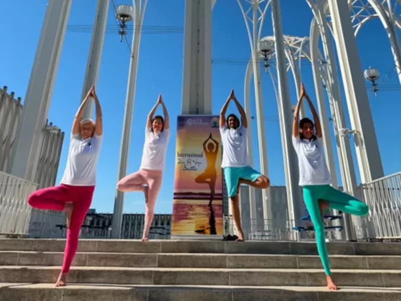 Participants perform yoga during an event organized by the Embassy of India in Kuwait