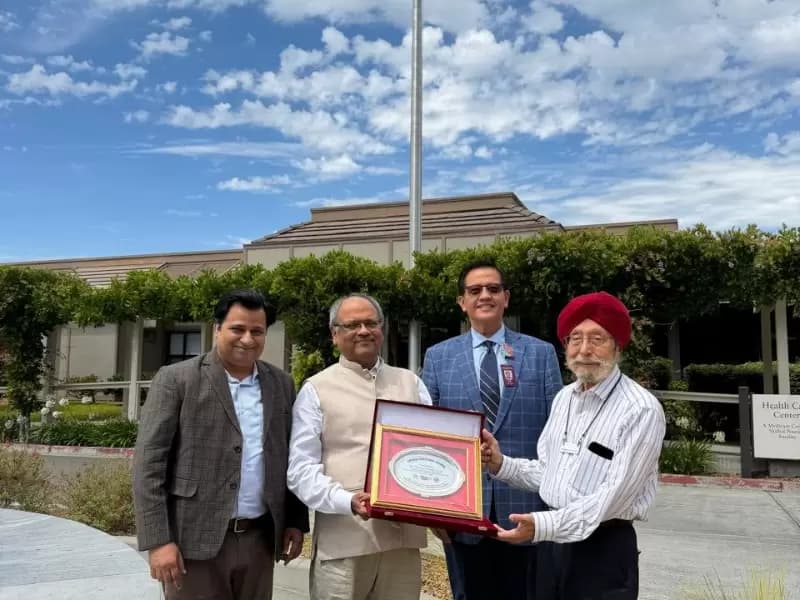 University officials handing over the award to Singh (R) at his residence in the US 