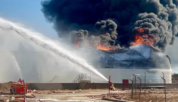 The photo shows a fuel tank burning at the Zawiya oil refinery in Zawiya, western Libya.