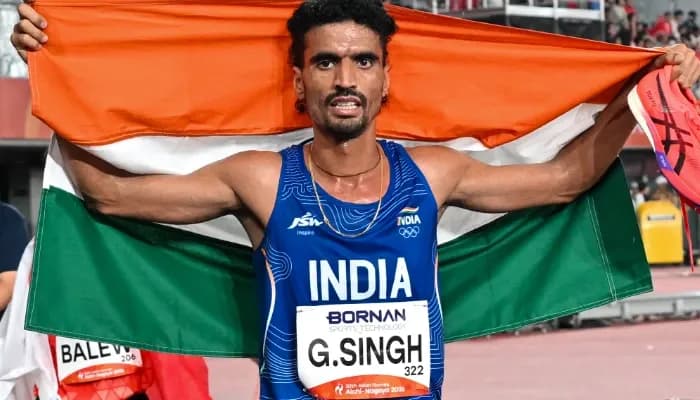 India’s Gulveer Singh celebrates with the national flag after winning the silver medal in the men’s 10,000m final at the 20th Asian Games Aichi-Nagoya 2026,