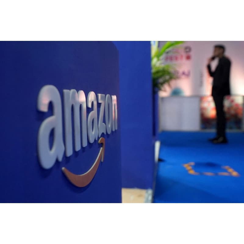 A visitior stands near a logo of Amazon during the annual Retail Leadership Summit in Mumbai, India, February 27, 2025.