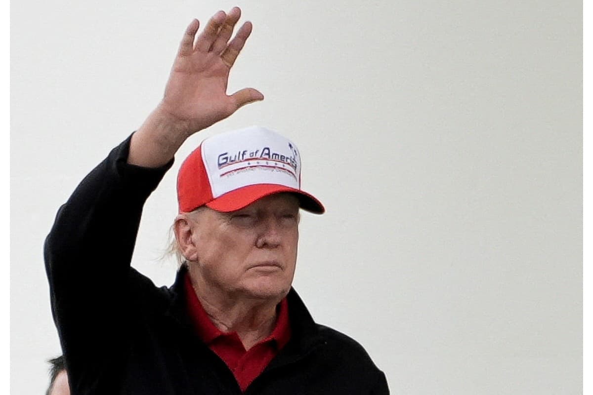 U.S. President Donald Trump gestures while wearing a hat that reads
