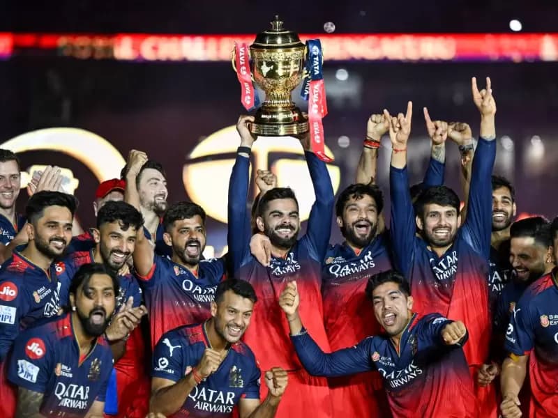 Royal Challengers Bengaluru players celebrate with the trophy after winning the Indian Premier League (IPL) 2025 final match against Punjab Kings, in Ahmedabad on Tuesday, June 3, 2025.