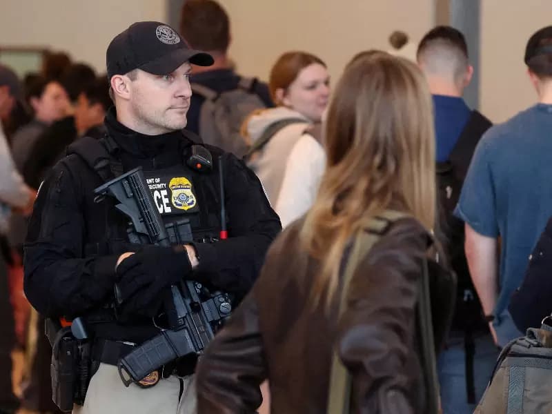 A federal agent patrols as people wait in line at New York's LaGuardia Airport in Queens, New York.