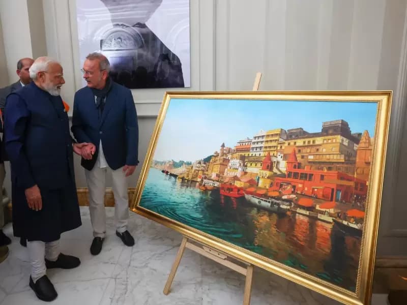 In the photo of the meeting shared in a post on X, the prime minister was standing with Tomassetti beside the large, colorful artwork depicting the sacred Ganges riverfront with boats and ghats.