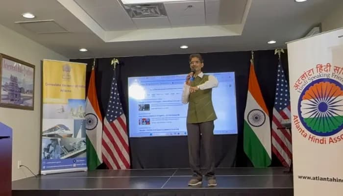 Hiten Bhuta speaks during the Hindi Divas program at the Consulate General of India in Atlanta on September 19, 2026, with Indian and U.S. flags and Hindi cultural program displays visible on the stage.